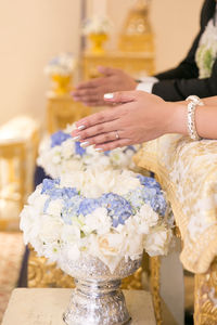 Close-up of women praying over flower bouquet