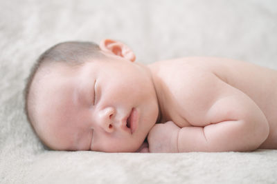Close-up of baby sleeping on bed
