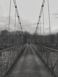 Footbridge over river against sky