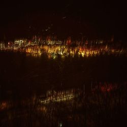 Illuminated lake against sky at night