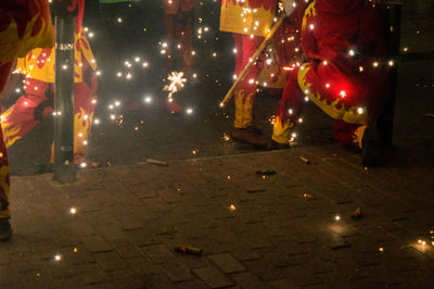Low section of people on illuminated street at night