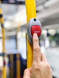 Close up with hand is pressing sign to stop on the bus.