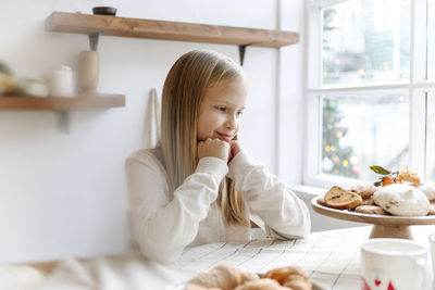 Portrait of woman sitting on table at home