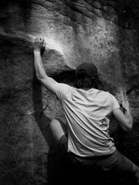 Rear view of man climbing on rock