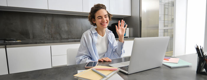 Young businesswoman using laptop while standing in office