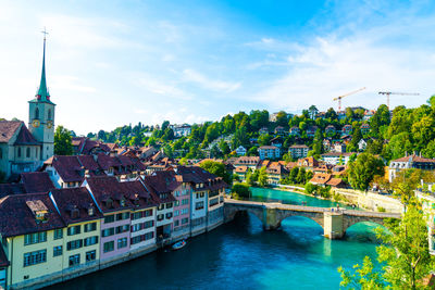 Bridge over river amidst buildings against sky