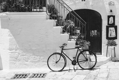 Bicycle parked on footpath by building