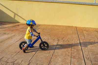 Side view of boy cycling on footpath