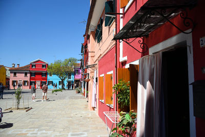 Houses by street in town against sky