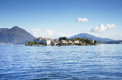Scenic view of sea and mountains against blue sky