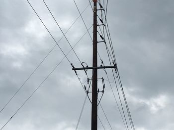 Low angle view of electricity pylon against sky