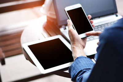 Midsection of man using mobile phone