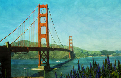 View of suspension bridge against blue sky