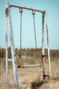 Abandoned swing against clear sky