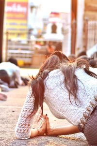 Rear view of woman sitting outdoors