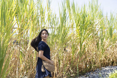 Portrait of woman standing by plants