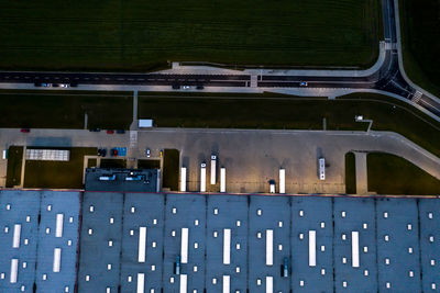 Night aerial view of goods warehouse. logistics center in industrial city zone from abovebtrucks