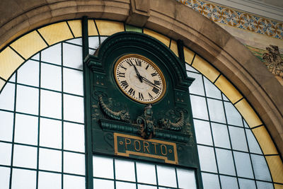 Low angle view of clock on glass wall of building