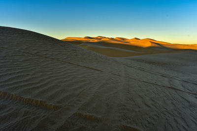 Scenic view of desert against sky during sunset