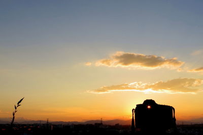 Silhouette city against sky during sunset