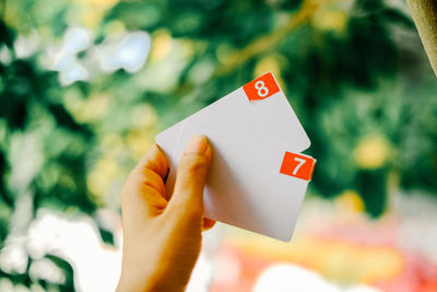 Close-up of hand holding placard outdoors