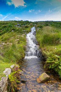 Scenic view of waterfall against sky