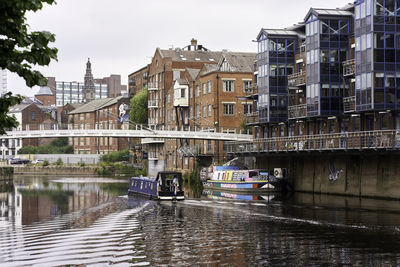 Canal amidst buildings in city against sky