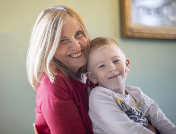 Portrait of smiling grandmother and grandson at home