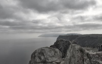 Mountains by sea with sky in background