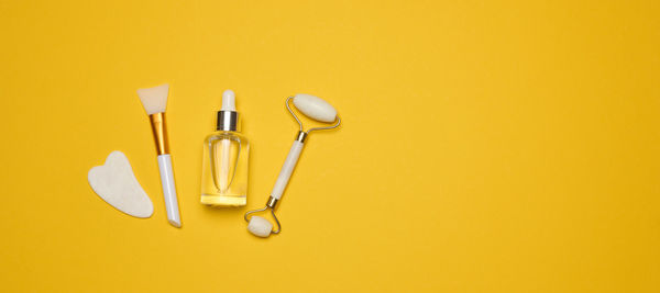 Directly above shot of beauty products against yellow background