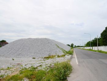 Empty road along landscape and against sky