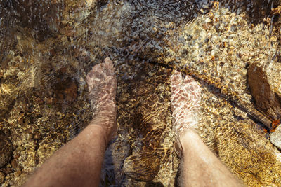 Low section of person on rock in water