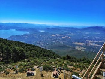 High angle view of mountain range and lake against blue sky