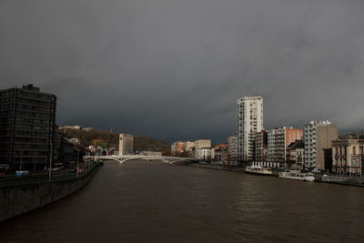 River amidst buildings in city against sky