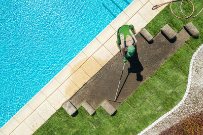 High angle view of man working by swimming pool