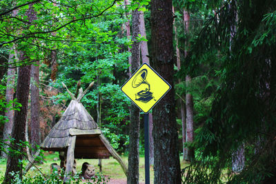 Road sign by trees in forest
