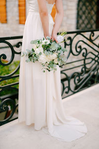 Midsection of woman holding flower bouquet