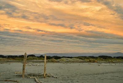 Scenic view of sea against cloudy sky at sunset