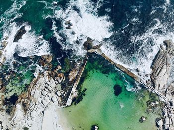 High angle view of sea splashing against rocks