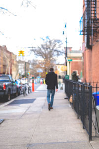 Rear view of a man walking on road