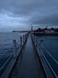 Pier over sea against sky at dusk