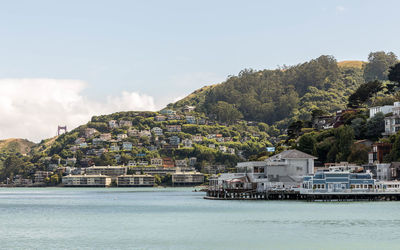 Scenic view of sea by buildings against sky