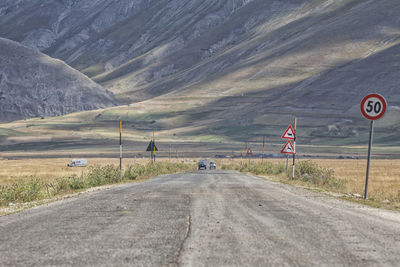 Vehicles on road against mountain