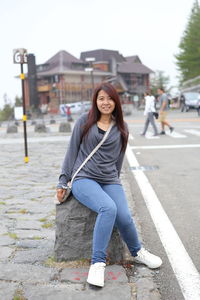 Portrait of smiling young woman on road in city
