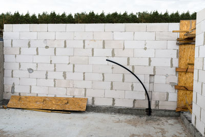 The walls of a house built of white brick with reinforced concrete pillars at the end of which 