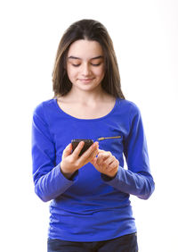 Smiling young woman standing against white background