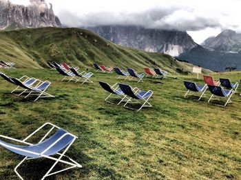 Empty foldable chairs on grassy field