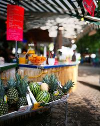 Pineapples and watermelons in crates for sale at street market