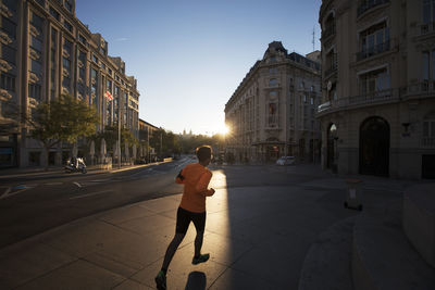 Rear view of man walking on street in city