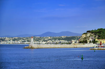 Scenic view of sea by city against sky